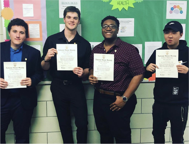 Photo of four students holding certificates